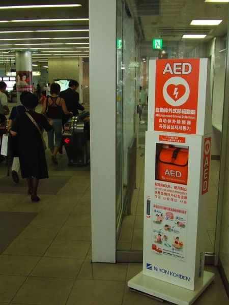 An AED at a railway station in Japan. The AED box has information on how to use it in Japanese, English, Chinese and Korean, and station staff are trained to use it.